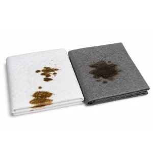 White and gray absorbent pads with visible oil stains, used to soak up oil and fuel spills from boats and marine equipment. Example materials accepted through the Oil & Absorbent Pad Exchange Program (OAEP).